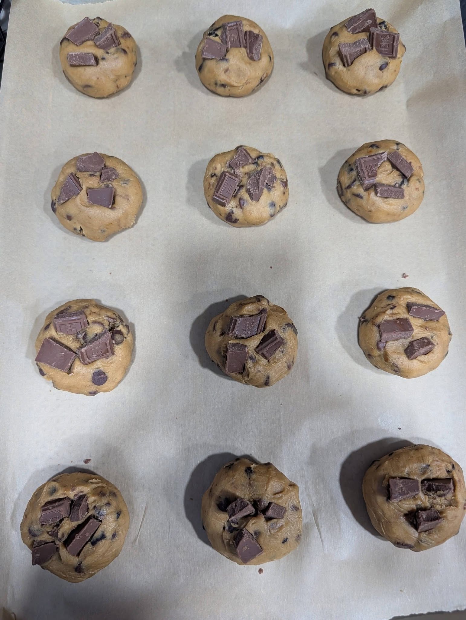 Cookie dough balls topped with chocolate chunks before baking