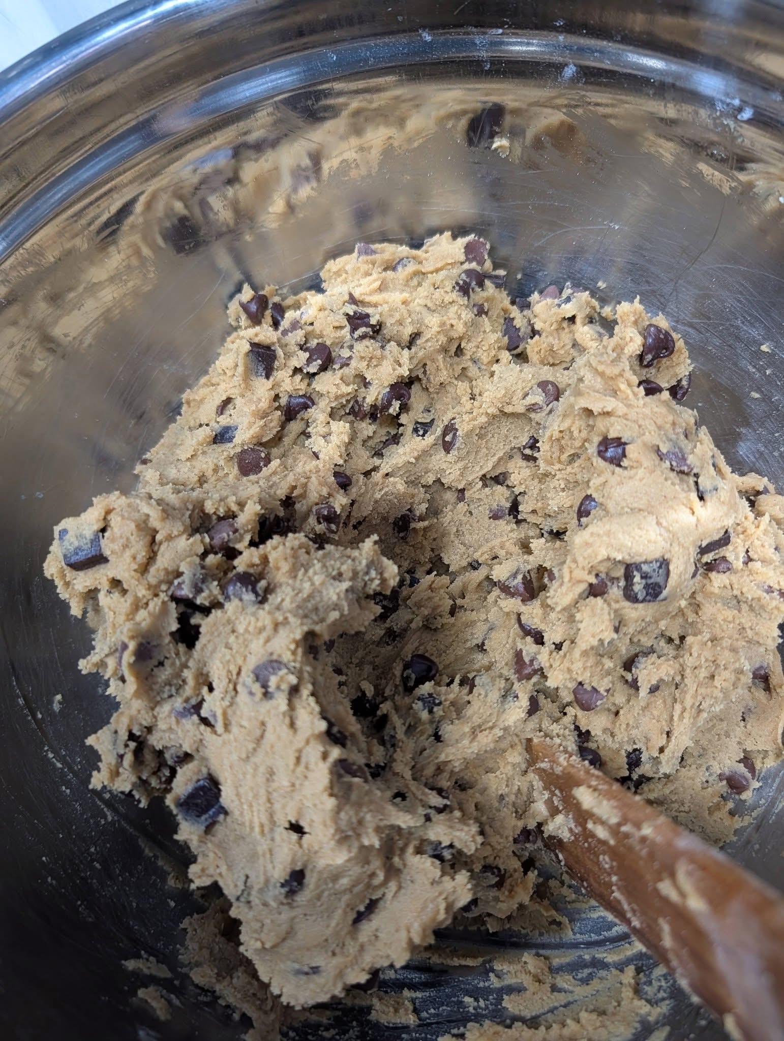 Cookie dough studded with chocolate chips in a mixing bowl
